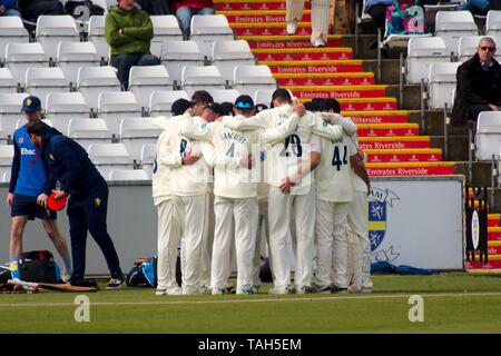 Chester le Street, England, 12 April 2019. The Durham CCC team huddle on the boundary before the start of the Sussex CCC innings in their Specsavers County Championship match at Emirates Riverside. Stock Photo