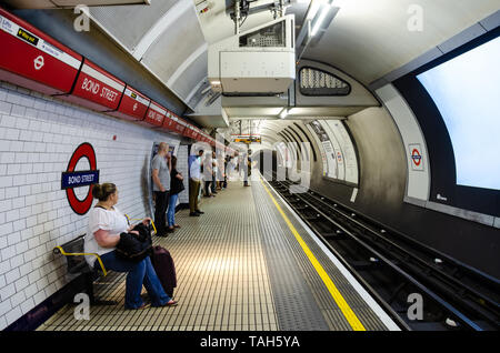 Passengers on the platform at Bond Street London Underground station wait for a central line train to arrive. Stock Photo