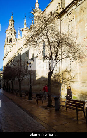 Logroño, La Rioja, Spain - February, 15th, 2019 : A woman walks past the south facade of the Co-Cathedral of Santa María de la Redonda along Calle Por Stock Photo