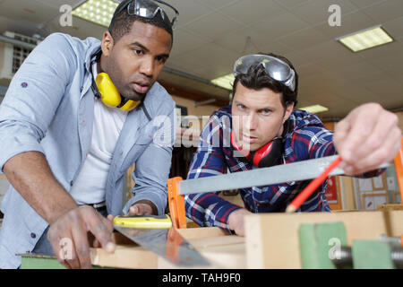 engineer teaching apprentices to use processing machines Stock Photo