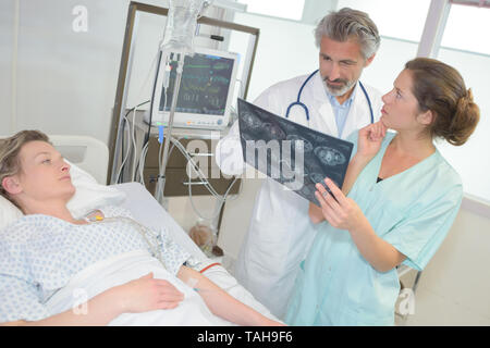 doctors examining patients xray in hospital room Stock Photo