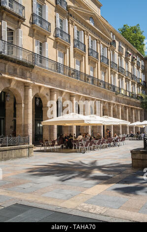 Customers sitting outside in Plaza Nueva (New Square), a popular location for eating and drinking in the Old Quarter of Bilboa, Basque Country, Spain. Stock Photo