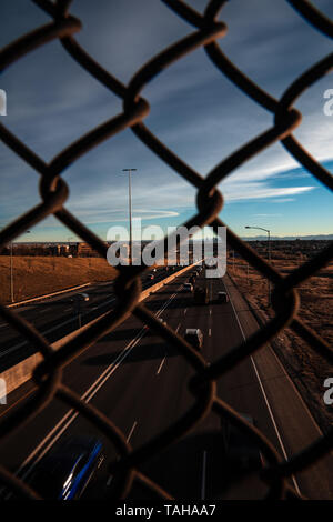 Highway view through fence Stock Photo