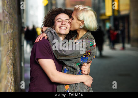 Young couple hugging in urban background on a typical London street.