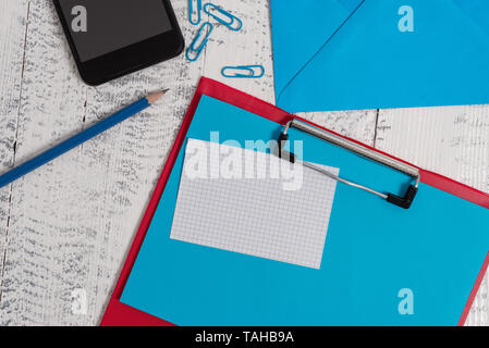 Clipboard sheet pencil note clips smartphone envelope wooden background Stock Photo