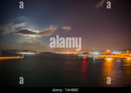 Night view of Athens Piraeus harbor with moon hidden by clouds, Greece Stock Photo