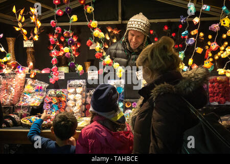 London, UK; 16th of November of 2016; Two excited kids with their grandma in a christmas market Stock Photo