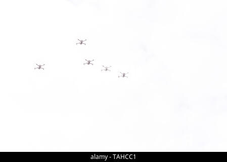 Five drones fly through the air. Drones on a background of gray sky. Unmanned aircraft outdoors. Flying quadrocopter in the sky. Technology Stock Photo