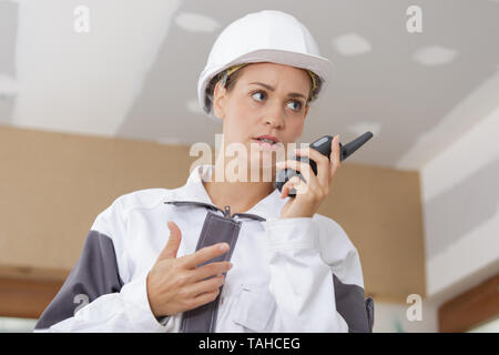 female construction worker using walkie-talkie Stock Photo