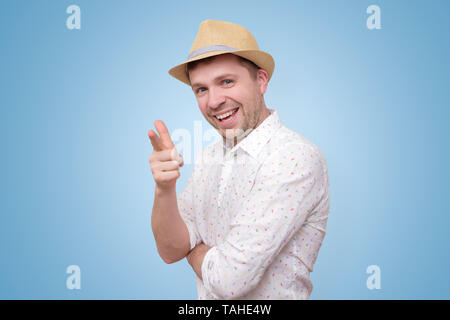 Cheerful man in summer hat pointing happily at you. Stock Photo