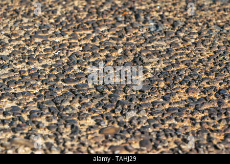 Rough wall texture of small burnt pebbles Stock Photo