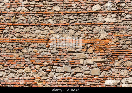 Composite old stone and bricks wall with rough surface as background Stock Photo