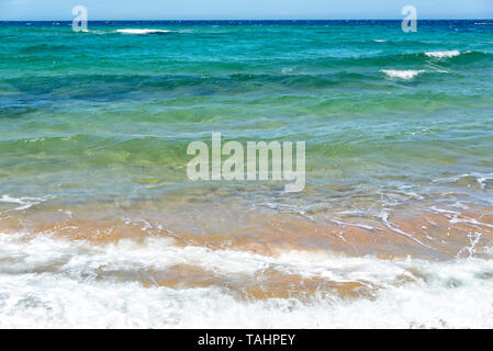 Waves on a beach with blue water Stock Photo