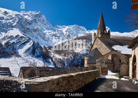 France, Hautes-Alpes (05), La Grave, Ecrins National Park - The church of Notre Dame de l'Assomption de la Grave in winter with view on La Meije Peak Stock Photo