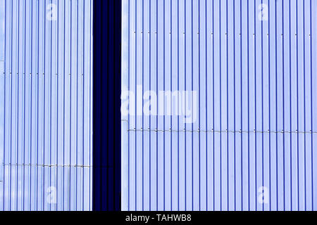 Light and dark blue corregated riveted metal wall Stock Photo