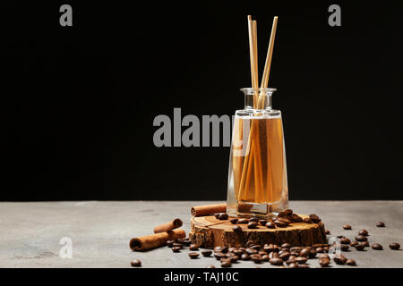 Reed diffuser, coffee beans and cinnamon on table Stock Photo