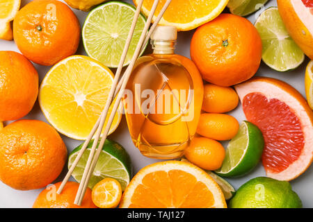 Reed diffuser and different citrus fruits on table Stock Photo