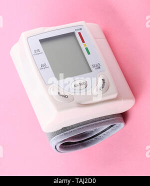 Automatic Wrist Digital blood pressure monitor on pink background at dry day Stock Photo