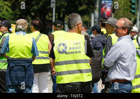 Wiesbaden, Germany. 25th May, 2019. A protester wears a yellow vest with 'No NWO QAnon 'written on it, referring to conspiracy theories about a New World Order and QAnon. Under 100 right wing protesters marched with yellow vests through Wiesbaden, to protest against the German government. They were confronted by small but loud counter protest. Credit: Michael Debets/Pacific Press/Alamy Live News Stock Photo
