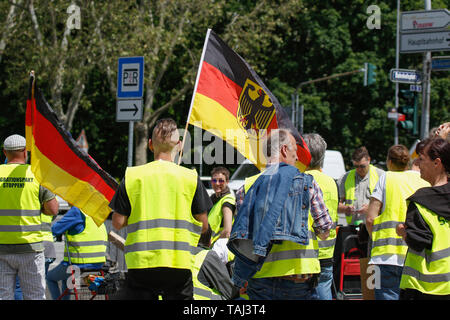 Wiesbaden, Germany. 25th May, 2019. Two protesters hold German flags. Under 100 right wing protesters marched with yellow vests through Wiesbaden, to protest against the German government. They were confronted by small but loud counter protest. Credit: Michael Debets/Pacific Press/Alamy Live News Stock Photo