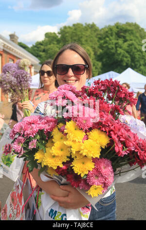 London UK. 25th May 2019. Members of the public carry exhibitor's plants and a wide variety of flowers on the last day of the 2019 Chelsea Flower Show at the Royal Horticultural Society flagship flower show which has been  held at the Royal Hospital since 1913 Stock Photo