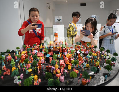 Chongqing, China. 24th May, 2019. Visitors look at an exhibit at a graduation exhibition of graduates from Sichuan Fine Arts Institute in Chongqing, southwest China, May 24, 2019. More than 10,000 pieces (sets) of works were displayed at the exhibition. Credit: Wang Quanchao/Xinhua/Alamy Live News Stock Photo