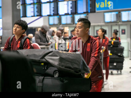 Paris, Chinese women's national football team's arrival at the Charles de Gaulle Airport in Paris, France. 25th May, 2019. Chinese player Li Ying (R, front) pushes the trolly upon Chinese women's national football team's arrival at the Charles de Gaulle Airport in Paris, France on May 25, 2019. Coaching staff, including head coach Jia Xiuquan, and 26 players landed here early morning on Saturday for final-phase preparation prior to the FIFA Women's World Cup. Credit: Han Yan/Xinhua/Alamy Live News Stock Photo