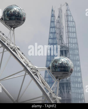 London, UK. 26th May 2019. Distant view of tourists on a London Eye pod against a background with top of The Shard shimmering through heat haze. Distance from imaging position to The Shard was 2.39 miles or 3.84 km. Credit: Malcolm Park/Alamy Live News Stock Photo