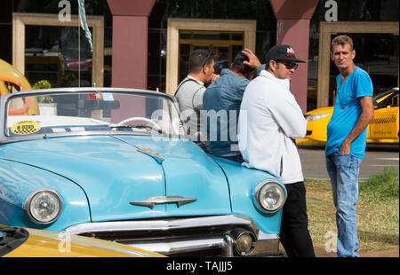 Havana, Cuba - Taxis wait for fares in front of Hotel Parque Central. Classic American cars from the 1950s, imported before the U.S. embargo, are comm Stock Photo