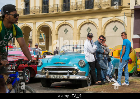 Havana, Cuba - Taxis wait for fares in front of Hotel Parque Central. Classic American cars from the 1950s, imported before the U.S. embargo, are comm Stock Photo