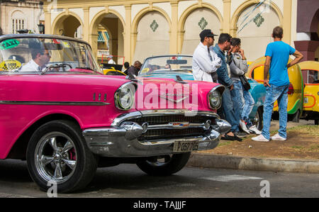 Havana, Cuba - Taxis wait for fares in front of Hotel Parque Central. Classic American cars from the 1950s, imported before the U.S. embargo, are comm Stock Photo