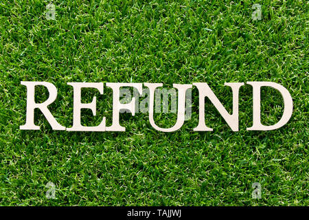 Wood alphabet in word refund on artificial green grass background Stock Photo
