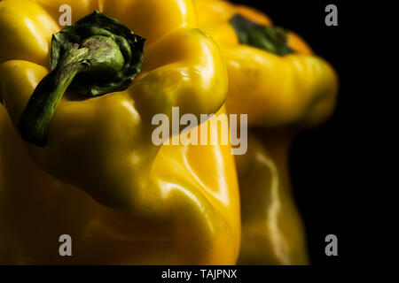 close-up yellow peppers with chiaroscuro on a dark background Stock Photo