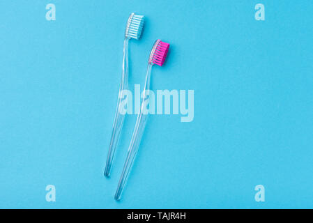 Two plastic colorful toothbrushes on blue background, close up Stock Photo