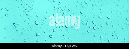 Water drops on glass panoramic blue background Stock Photo