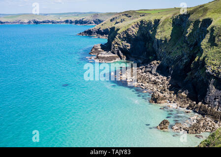 The rugged unspoiled coastline seen from the coast path in North Cornwall UK with clear turquoise sea on a sunny day. Stock Photo