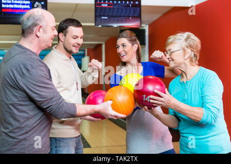 Portrait of a happy family holding multi colored bowling ball Stock Photo