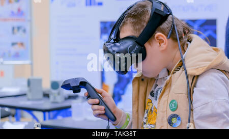 Teenager boy using virtual reality headset at technology show Stock Photo
