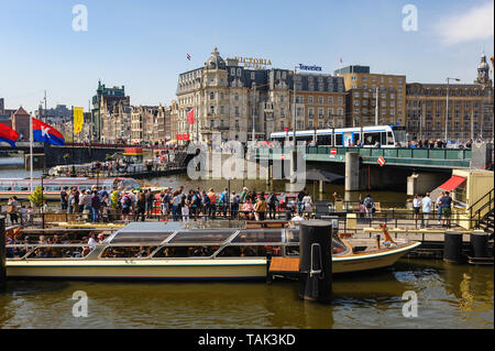 Amsterdam, Netherlands - 22 April 2019: Tourists sightseeng at Canal Boat City Hopper near the Central Station of Amsterdam. Stock Photo