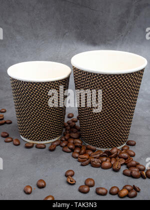 two empty coffee paper cups and coffee beans on concrete background, copy space Stock Photo