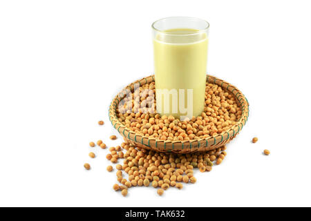 Soy milk in the glass and soybean seeds on threshing basket isolated on white background - soya beans Stock Photo