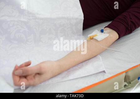 patient having IV drip and lying at hospital ward. Illness Stock Photo