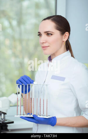 Laboratory scientist holding blood samples in a test tube rack. Blood research Stock Photo