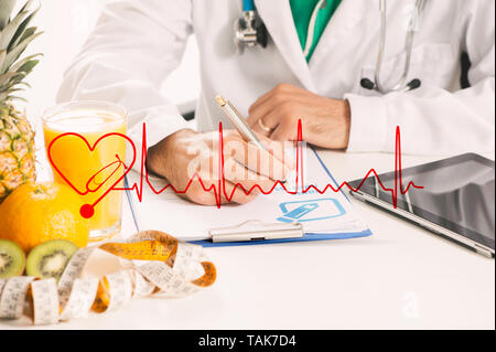 Dietitian doctor writing a diet list with fruit on a desk Stock Photo
