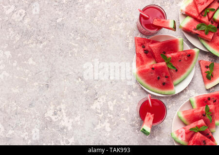 Fresh ripe watermelon slices and juice on grey background Stock Photo