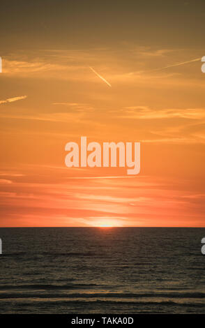 Sun setting over the sea Stock Photo