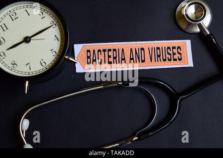 Bacteria and Viruses on the paper with Healthcare Concept Inspiration. alarm clock, Black stethoscope. Stock Photo