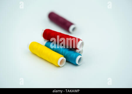 spool of thread many of different colors isolated on white background Stock Photo