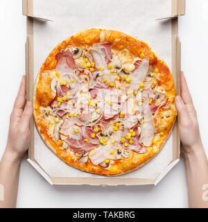 Cashier Holding Box With Delicious Pizza On White Table Stock Photo