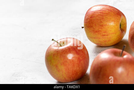 Bright red and yellow apples - fuji kiku variety - on white board, sapce for text left Stock Photo